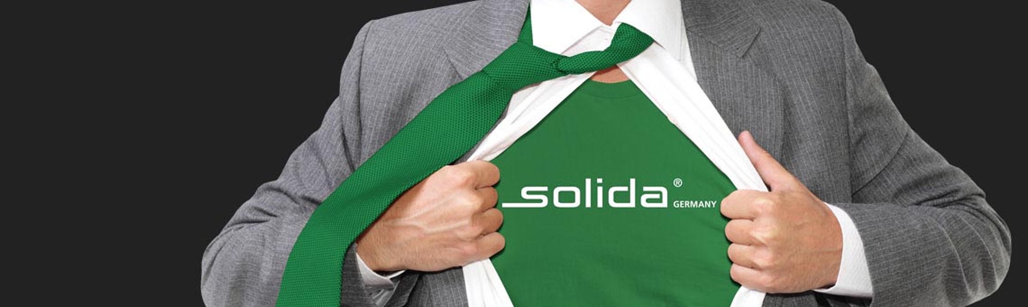 Mann in Anzug und Krawatte zeigt Shirt mit SOLIDA Logo
